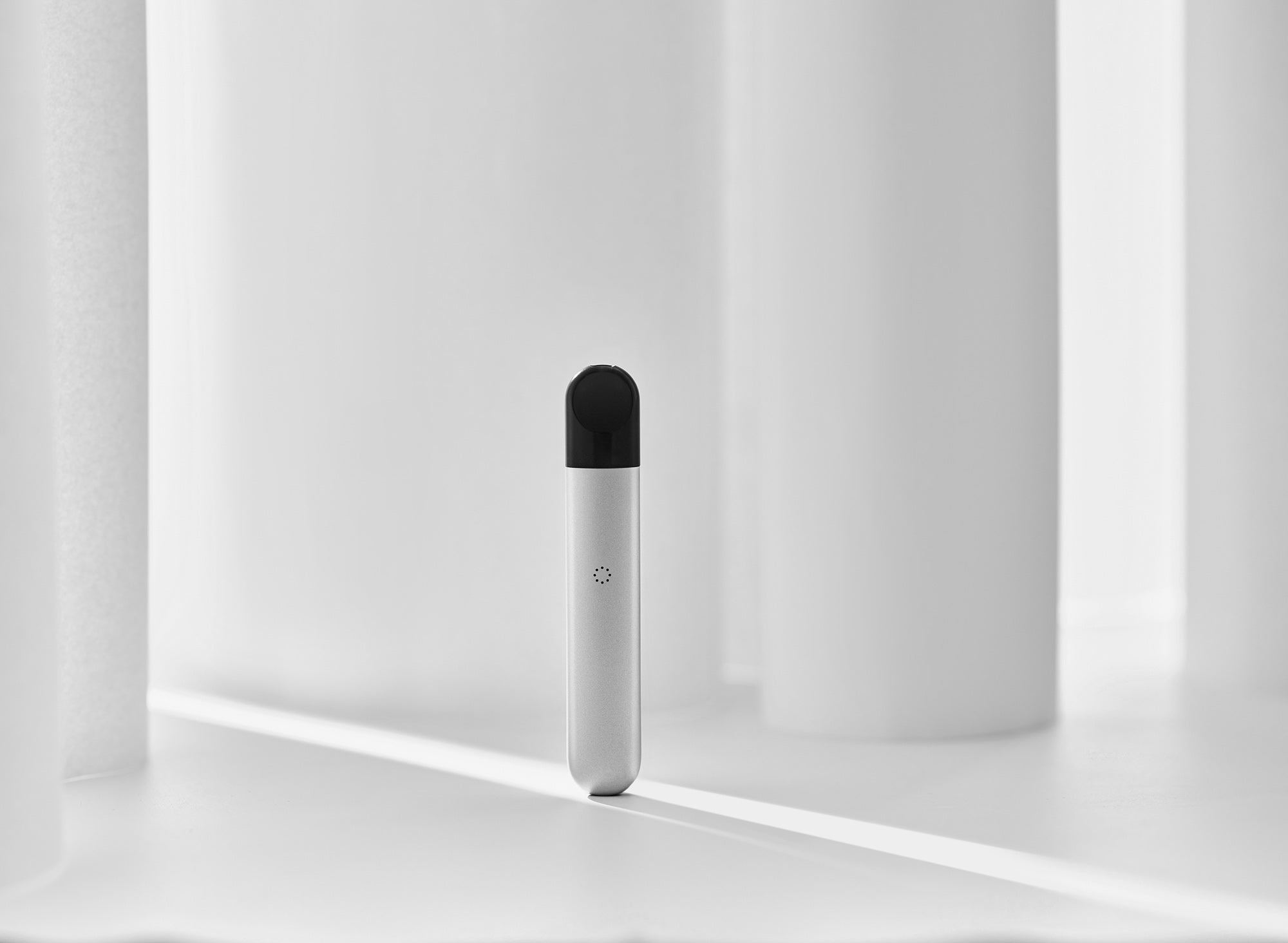 A white RELX Infinity vape against white objects.