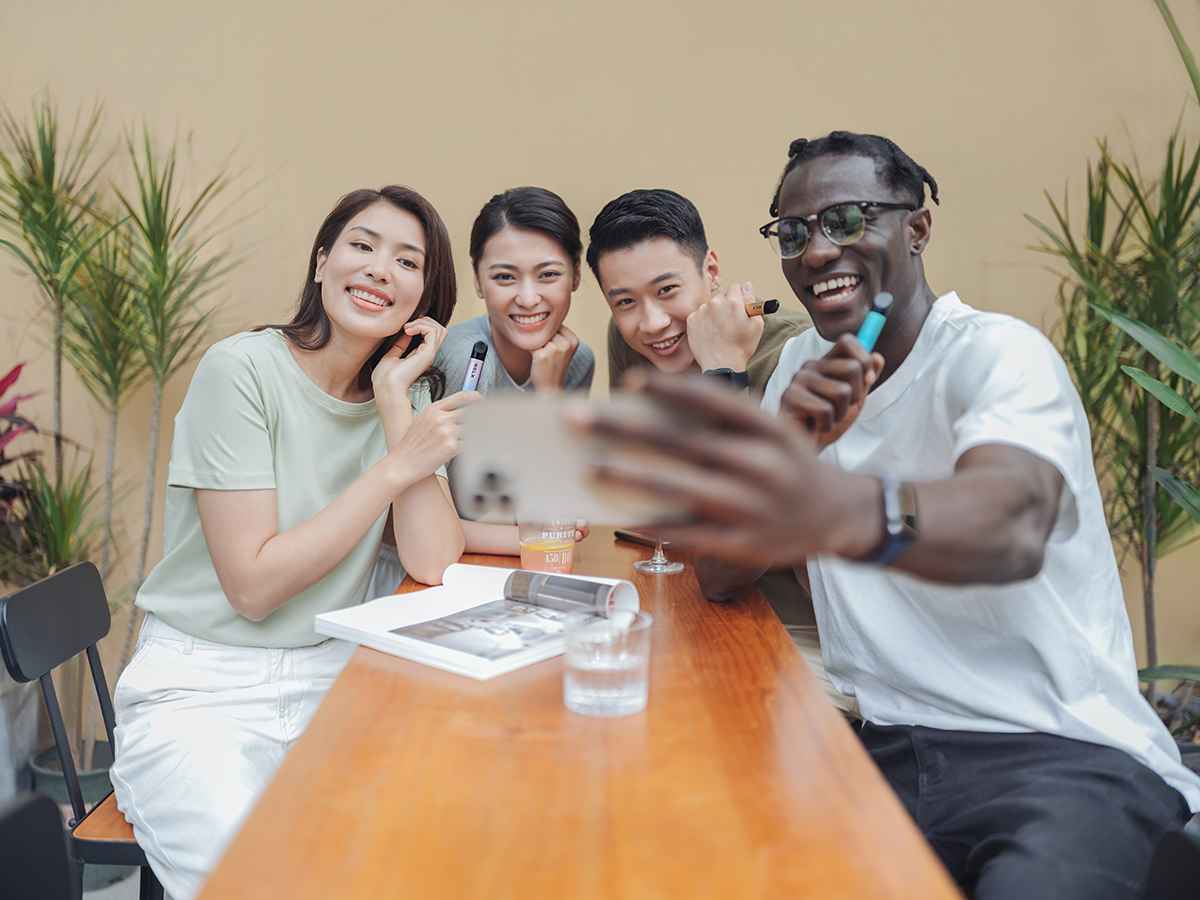 Man uses his RELX device with friends.
