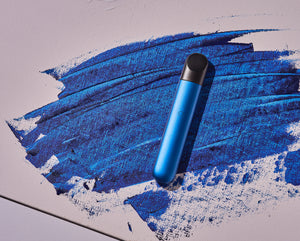 A product image of the RELX Infinity device in blue against a textured blue and off-white background.