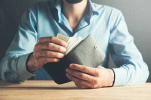 A man is holding money from his wallet